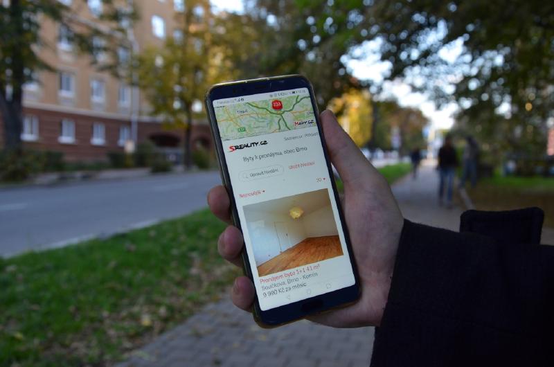 Na obrázku je chytrý telefon s inzercí nájemních bytů v Brně